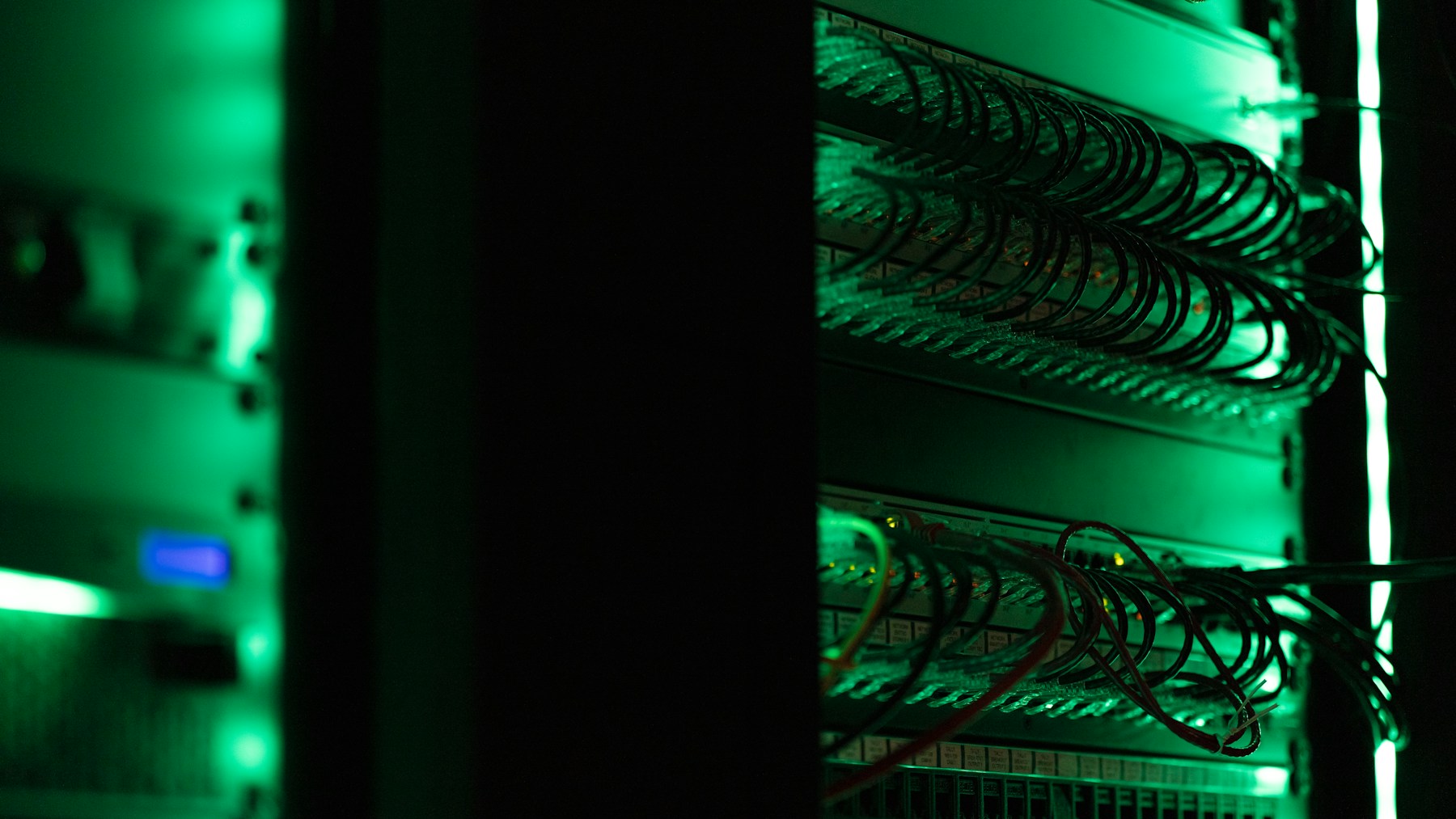 Netzwerkverkabelung in einem Serverschrank, grün beleuchtet